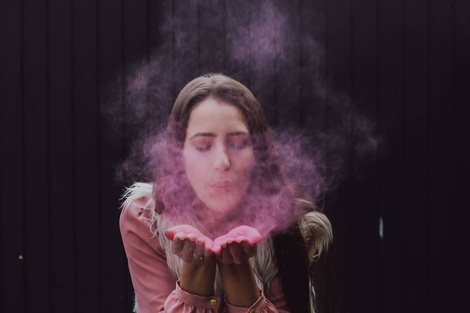 woman blowing smoke on her both hands